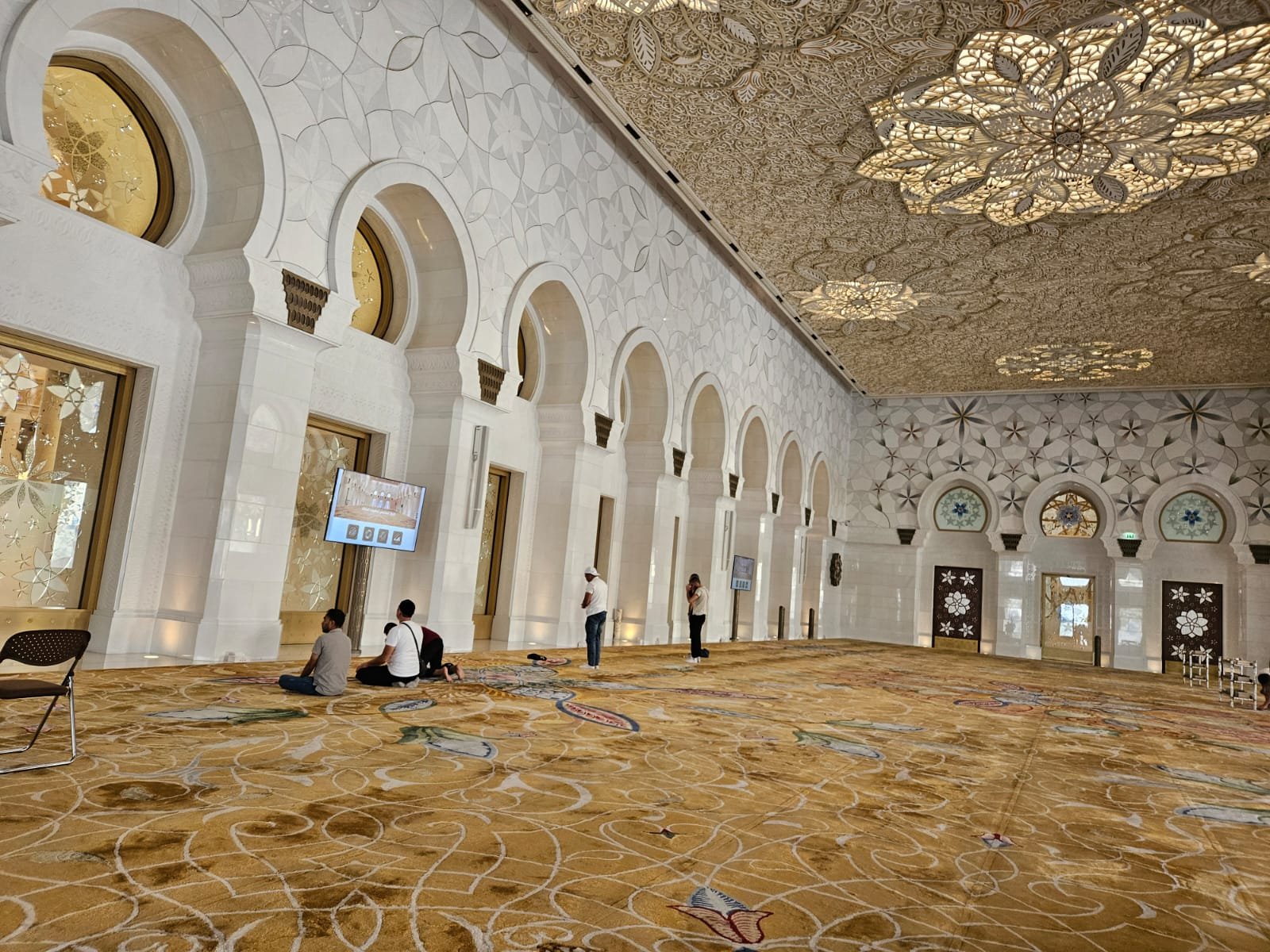 designed handmade carpet inside the prayer hall of Sheikh Zayed Grand Mosque, featuring floral patterns and vibrant colors